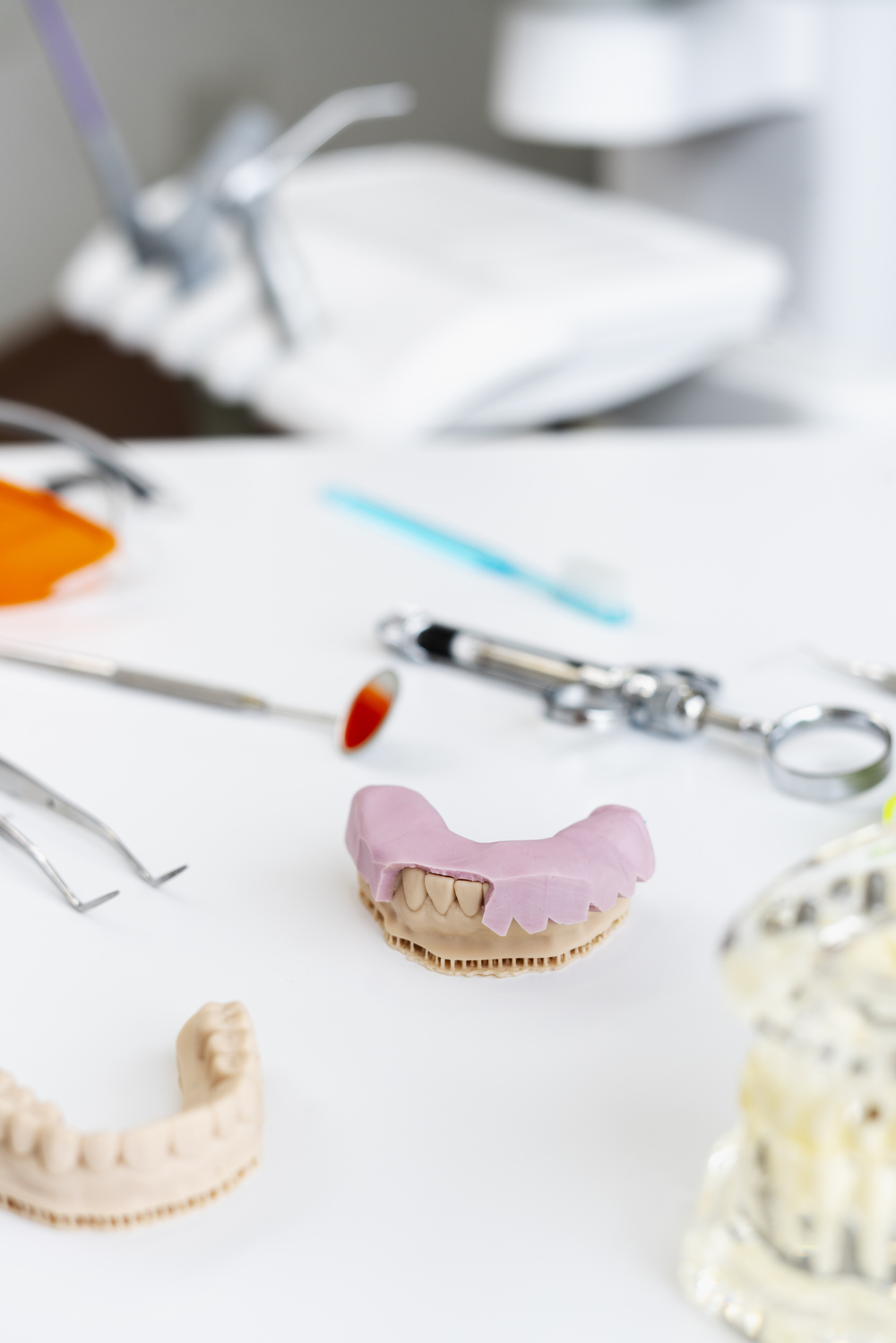 Dental office, cast of teeth, false teeth, implants, dental tools on workplace. Modern office medicine. Concept of health care